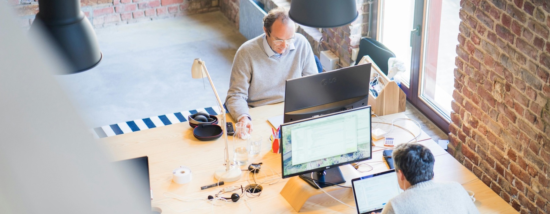 people working at desks in a naturally lit room 